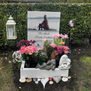 front picture of installed peaceyard gravestone, model ada in glacier white color with standard base and square planter