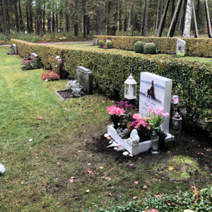 side picture of installed peaceyard gravestone, model ada in glacier white color with standard base and square planter