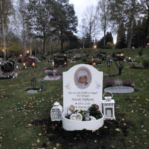 picture of installed peaceyard gravestone, model cora in glacier white with round planter