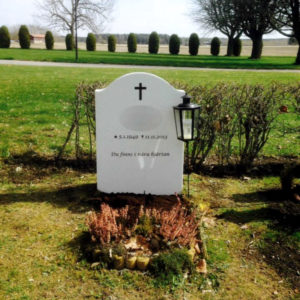 picture of installed peaceyard upright gravestone, model cora in glacier white material with customer graphics