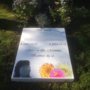 picture of installed peaceyard horizontal gravestone, model custom flora in glacier white color with customer graphics