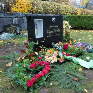 picture of installed peaceyard upright gravestone, custom model in night sky material with customer graphics and integrated lantern with flush glass