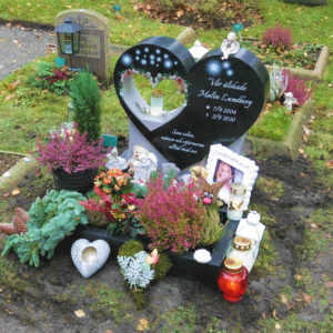 picture of installed peaceyard upright gravestone, custom model in night sky material with dove material inserts with customer graphics, integrated lantern and square planter
