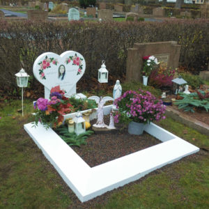 picture of installed peaceyard upright gravestone, model melody in glacier white material with customer graphics and everest square angeled frame