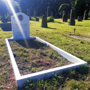 picture of installed peaceyard upright gravestone, Cora in glacier white material with customer graphics